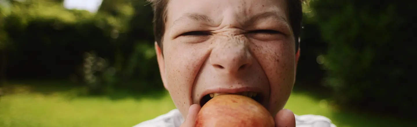 Ein Junge beißt in einen Apfel