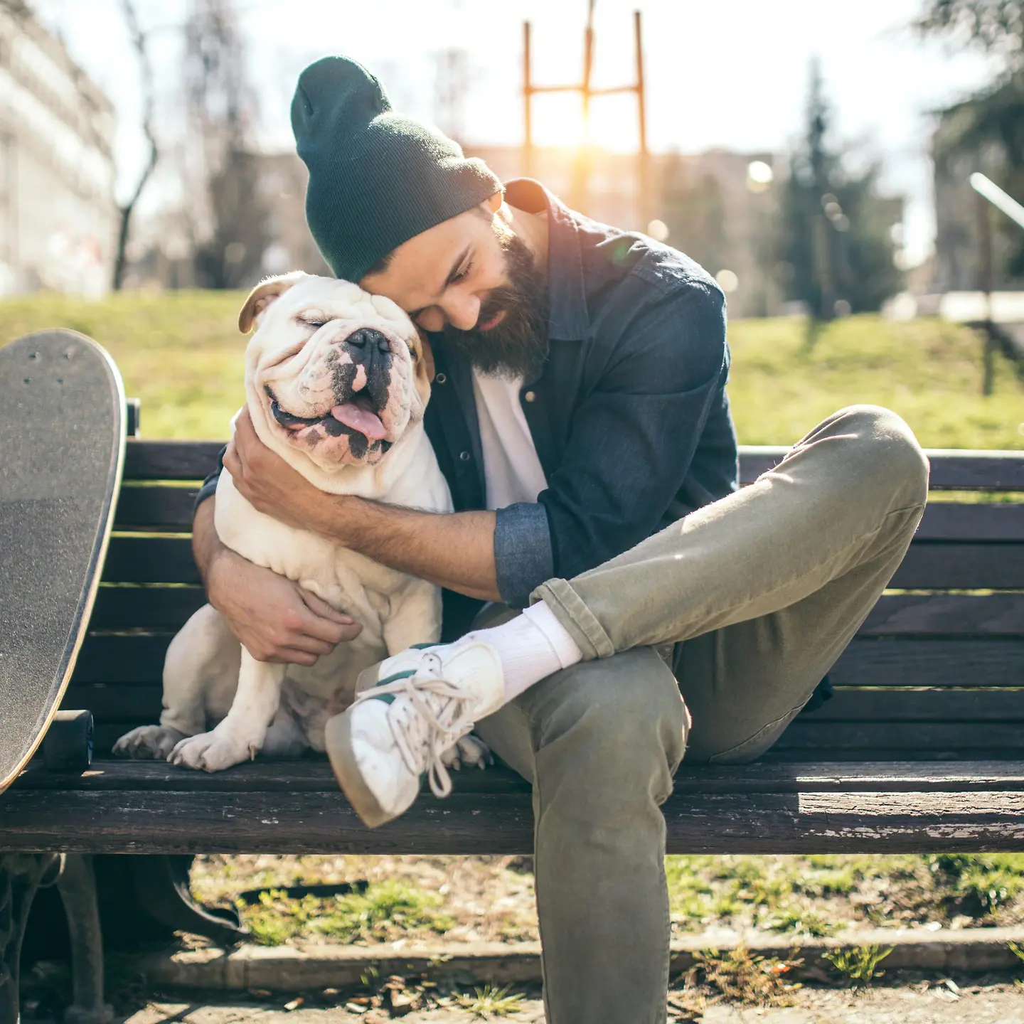 Skater sitzt mit seinem Hund auf einer Bank