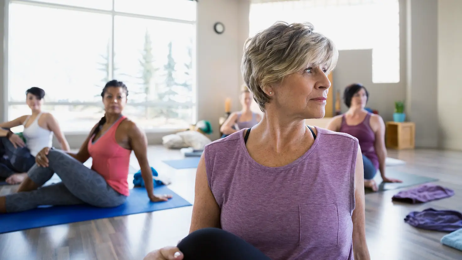 Zu sehen sind Seniorinnen auf Yogamatten